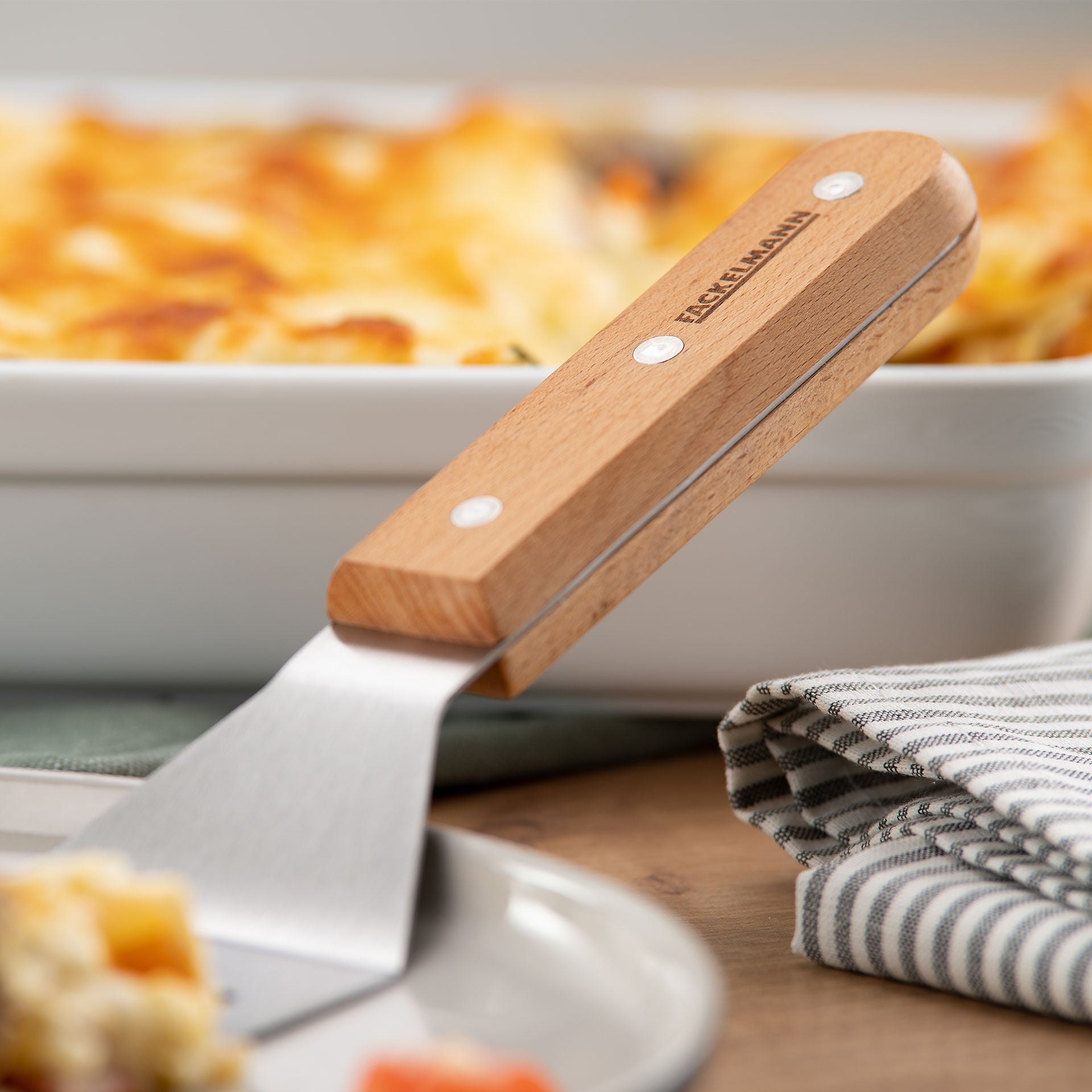 Nærbilde av bladet på lasagnespade rustfritt stål med bøketrehåndtak FSC-sertifisert