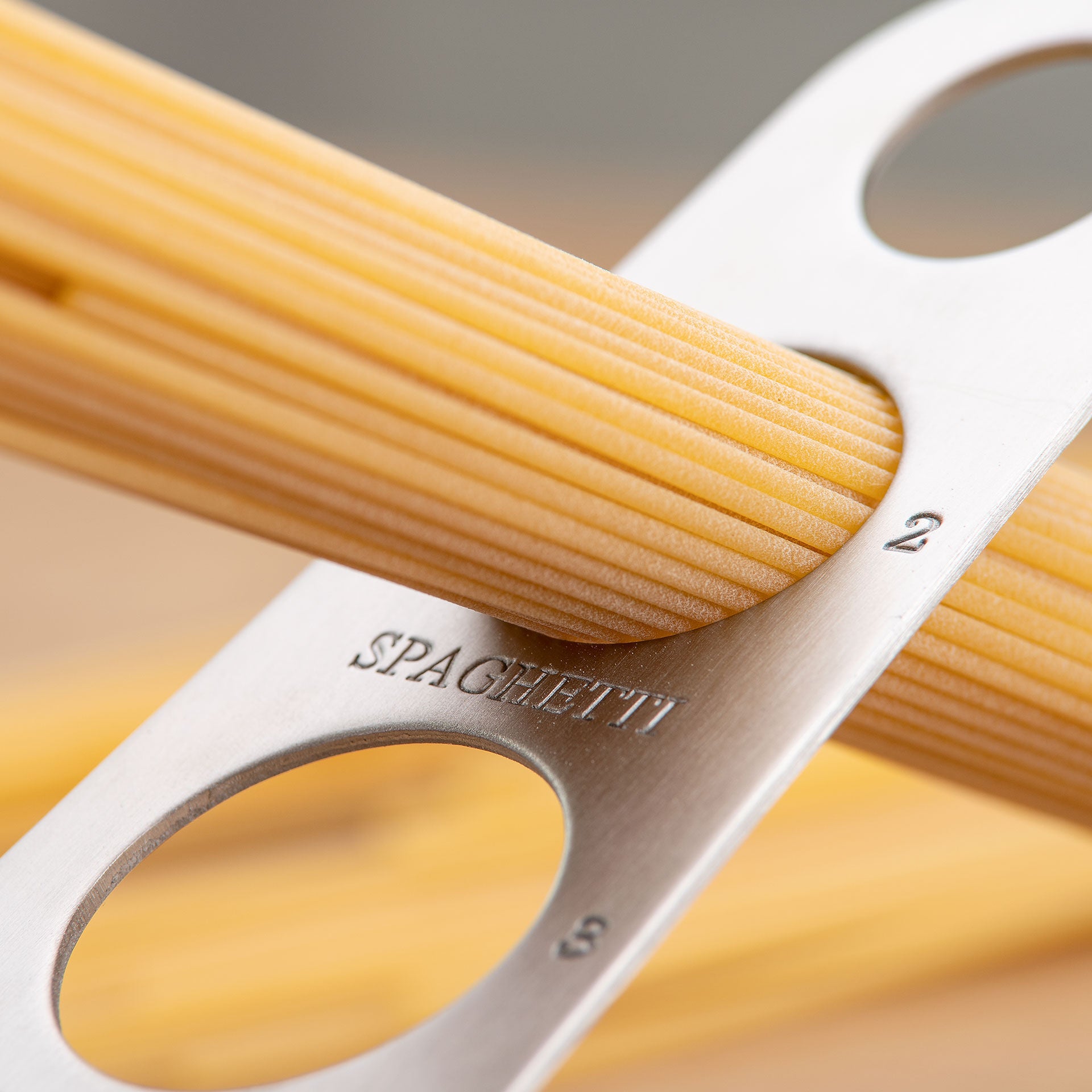 Nærbilde av hullene på Spaghettimål rustfritt stål med porsjonsmåler