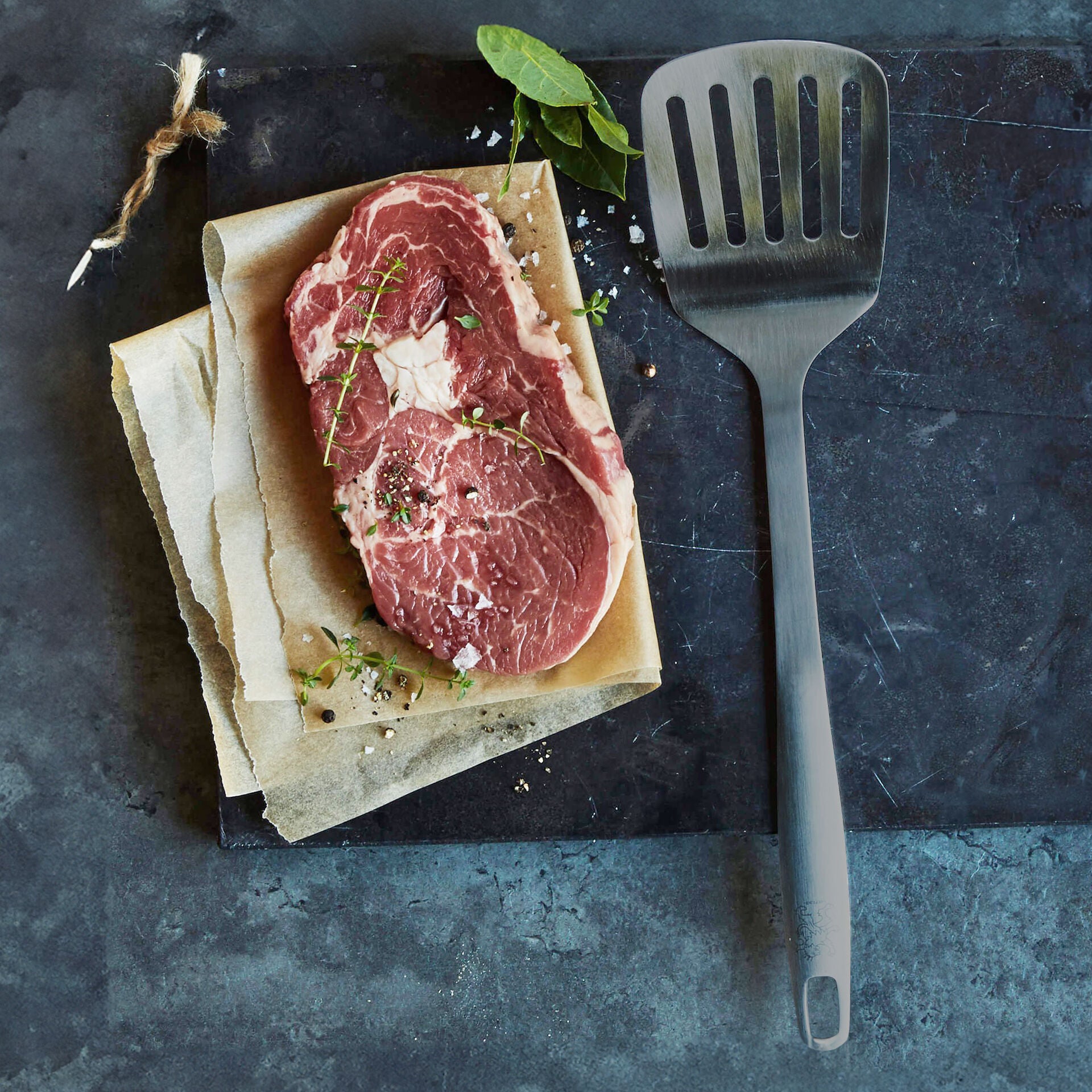 Stekespade med spalter svart rustfritt stål 32,5 cm sett bakfra